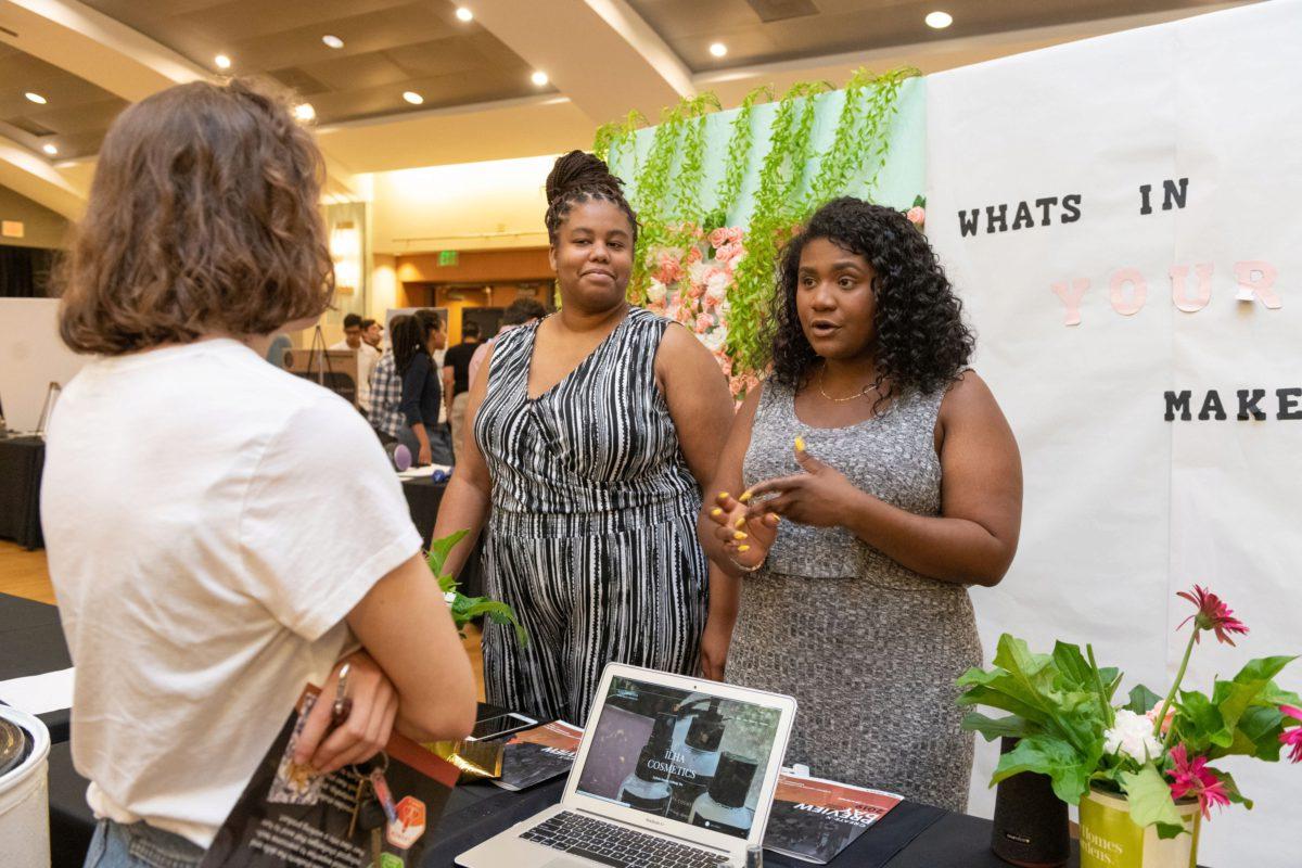 Founders discussing their makeup company with an attendee, photo